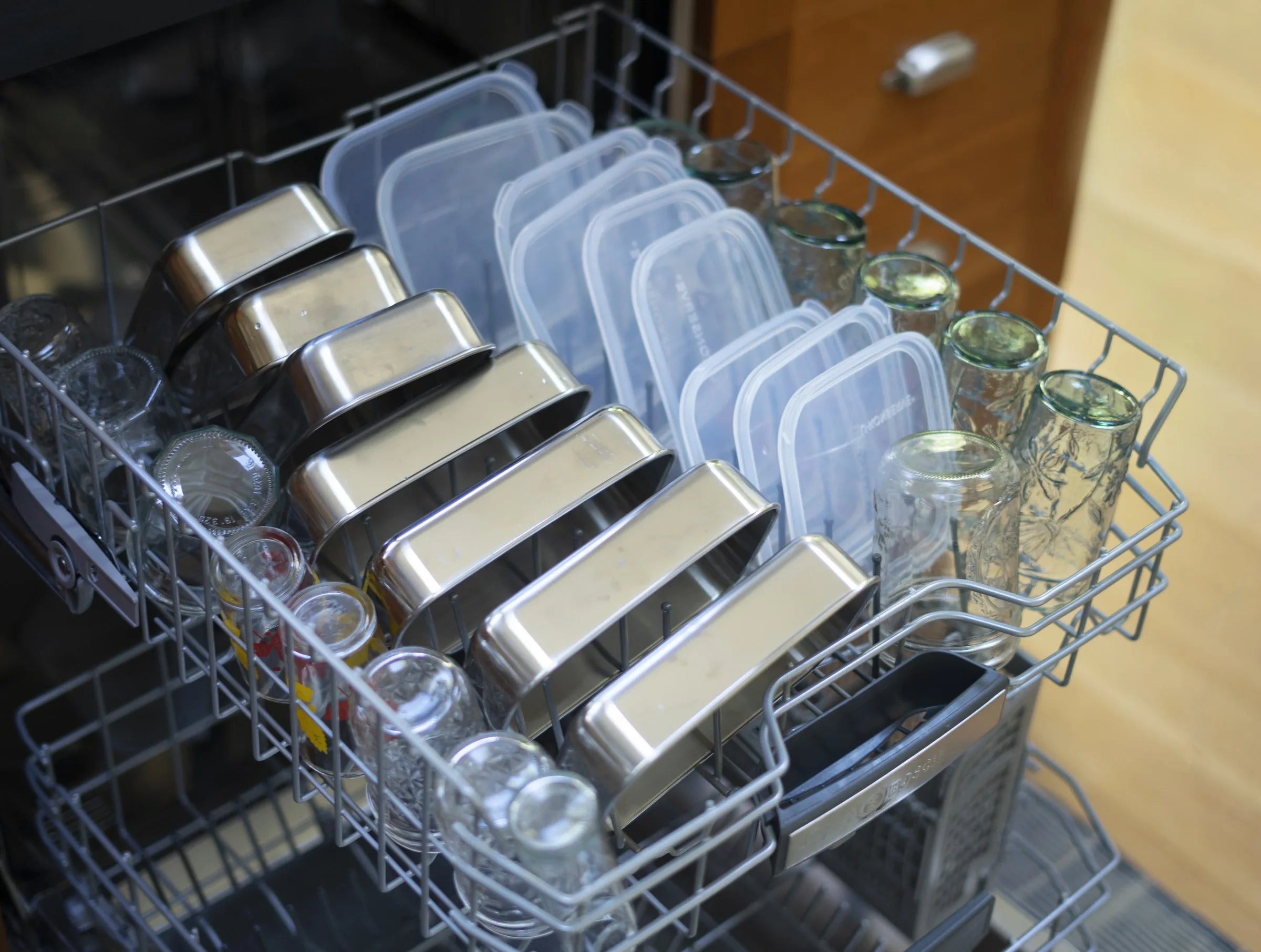 Stainless steel squares and clear silicone lids in a dishwasher rack